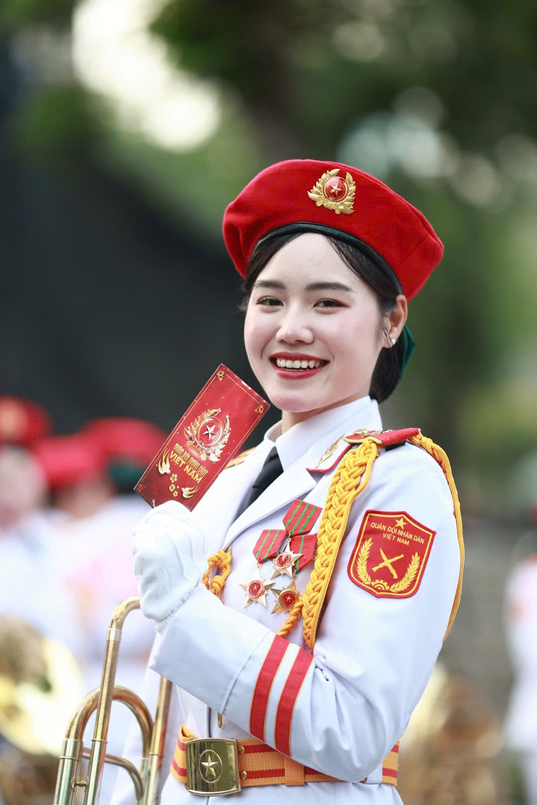 Các nữ chiến sĩ thuộc khối Quân nhạc đứng trang nghiêm trước lá cờ Mặt trận Dân tộc giải phóng miền Nam Việt Nam. Đây là một trong những nữ chiến sĩ đại diện hình ảnh “bông hồng thép” thuộc lực lượng Quân đội Nhân dân Việt Nam.