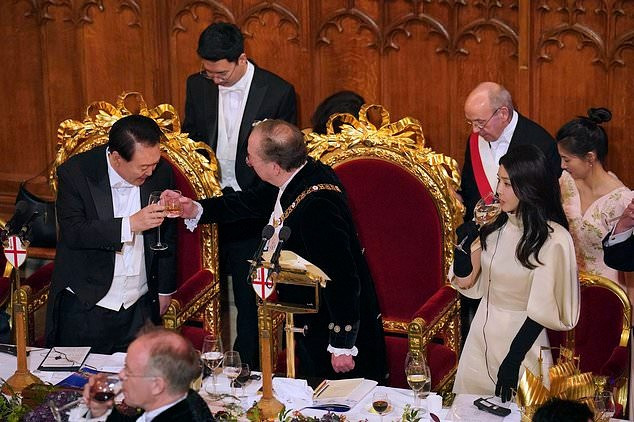 Trong buổi gặp Thị trưởng Thành phố London, Anh, bà Kim Kun Hee chọn trang phục chất liệu lụa sang trọng, chi tiết tay phồng và bao tay thể hiện phong thái hoàng gia. Sau khi xuất hiện trong chuyến thăm đến Anh, truyền thông xứ kim chi liên tục khen cách giữ dáng, tìm hiểu bí quyết trẻ đẹp của bà ở tuổi 51.