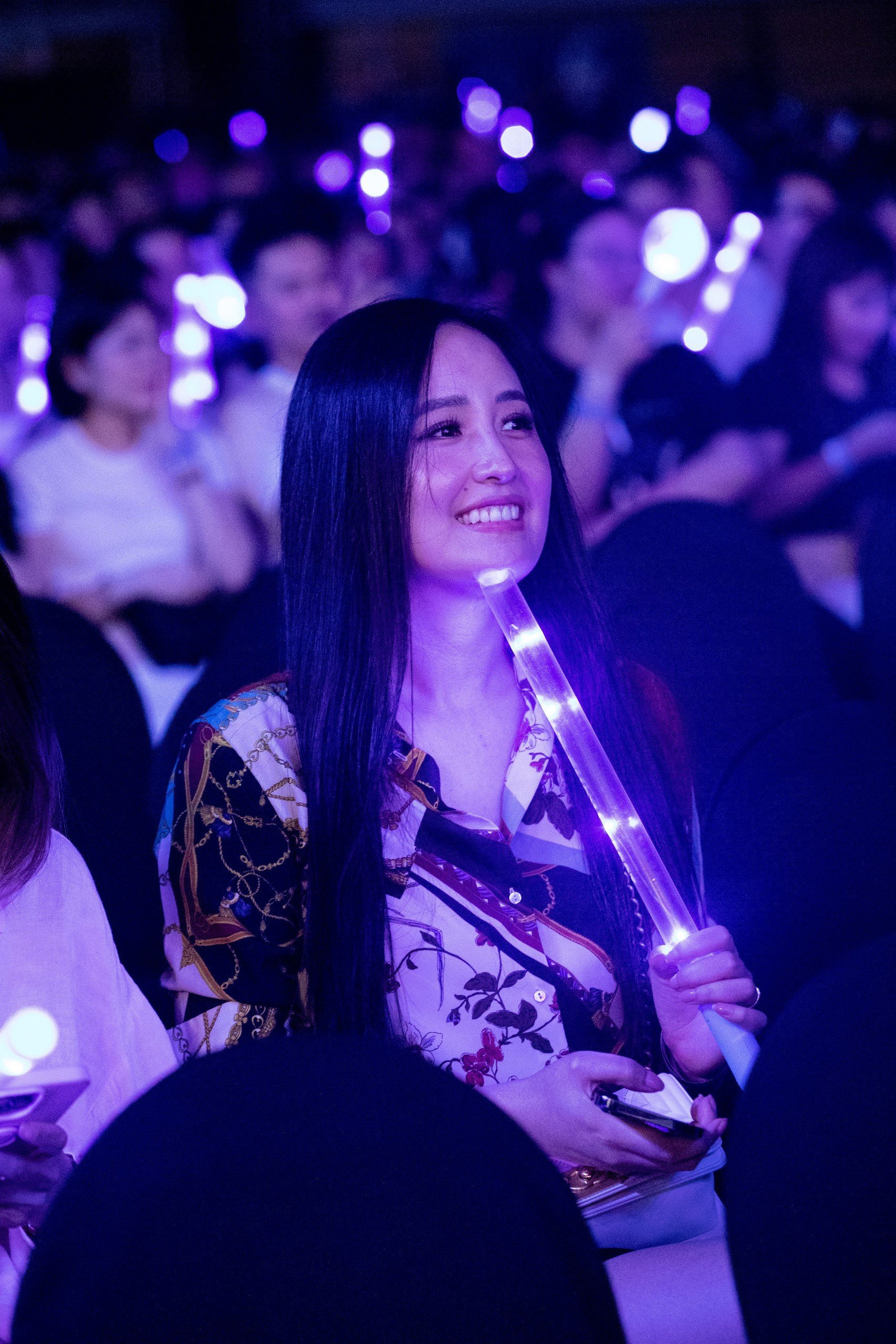 Mai Phương Thúy diện áo sơ mi in hoa đến đêm nhạc. Cô trang điểm nhẹ, mang theo lightstick ủng hộ Trung Quân.