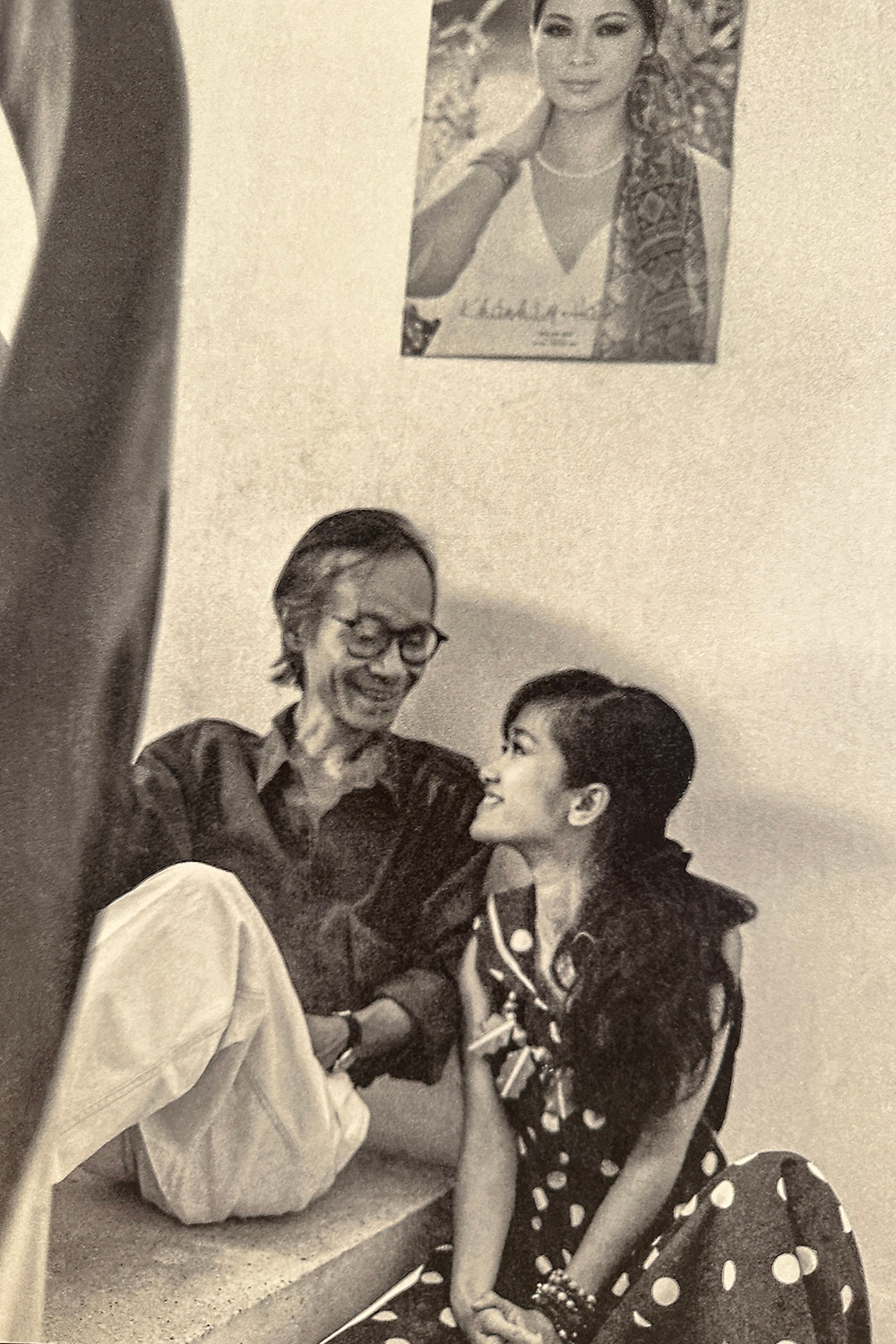 Khoảnh khắc Trịnh Công Sơn ngồi bệt dưới chân cầu thang trò chuyện cùng Hồng Nhung, bên trên là bìa poster Hạ trắng của Khánh Ly. Đây là những ngày đầu Hồng Nhung vào TPHCM lập nghiệp. Ảnh: Dương Minh Long.