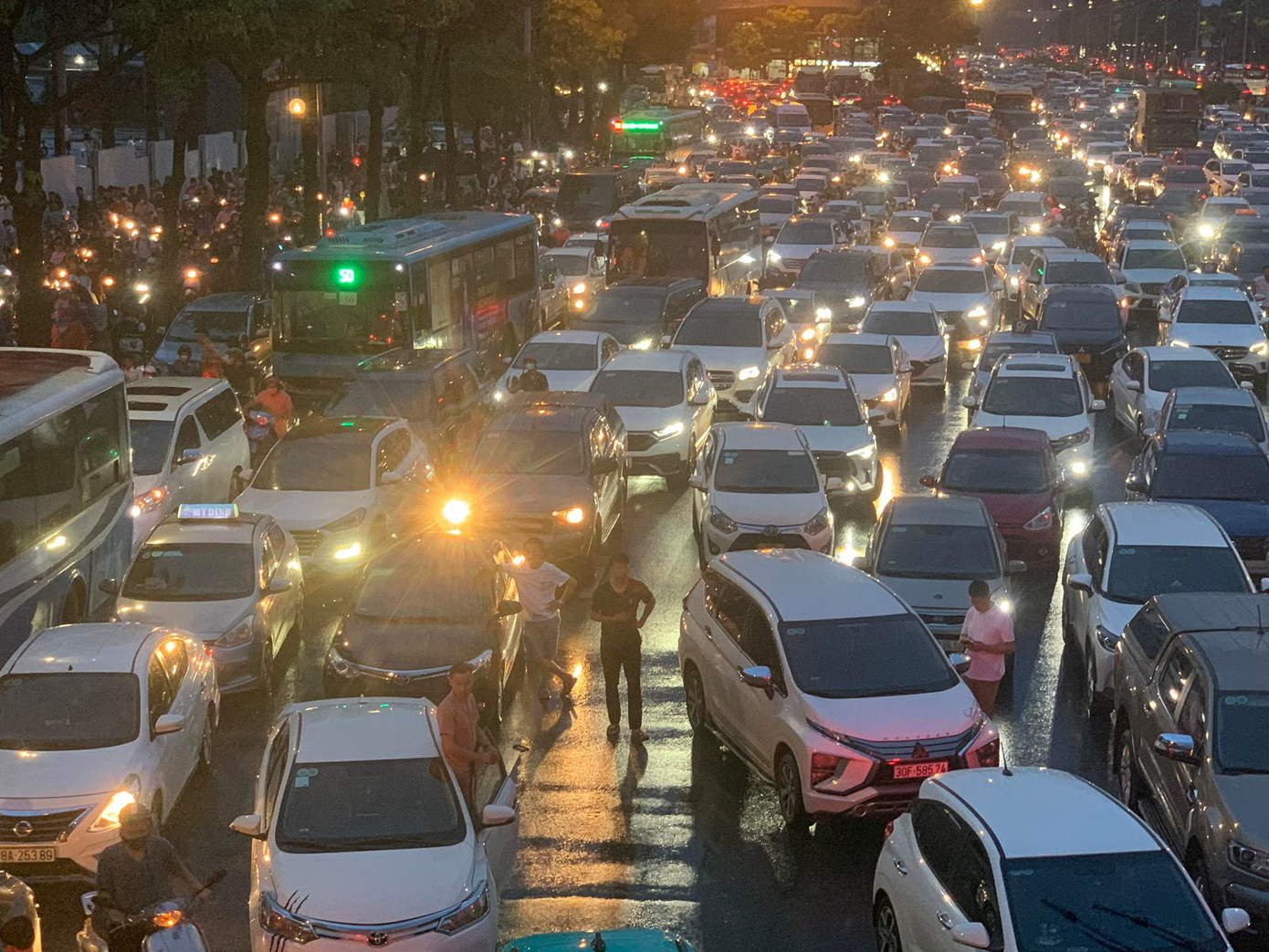 Ngoài phố, trời mưa, cộng với người đông đúc khiến tắc đường dài hàng km trên đường Lê Quang Đạo, trước cổng sân vận động Mỹ Đình. Nhiều tài xế dừng xe, ra bên ngoài đợi.