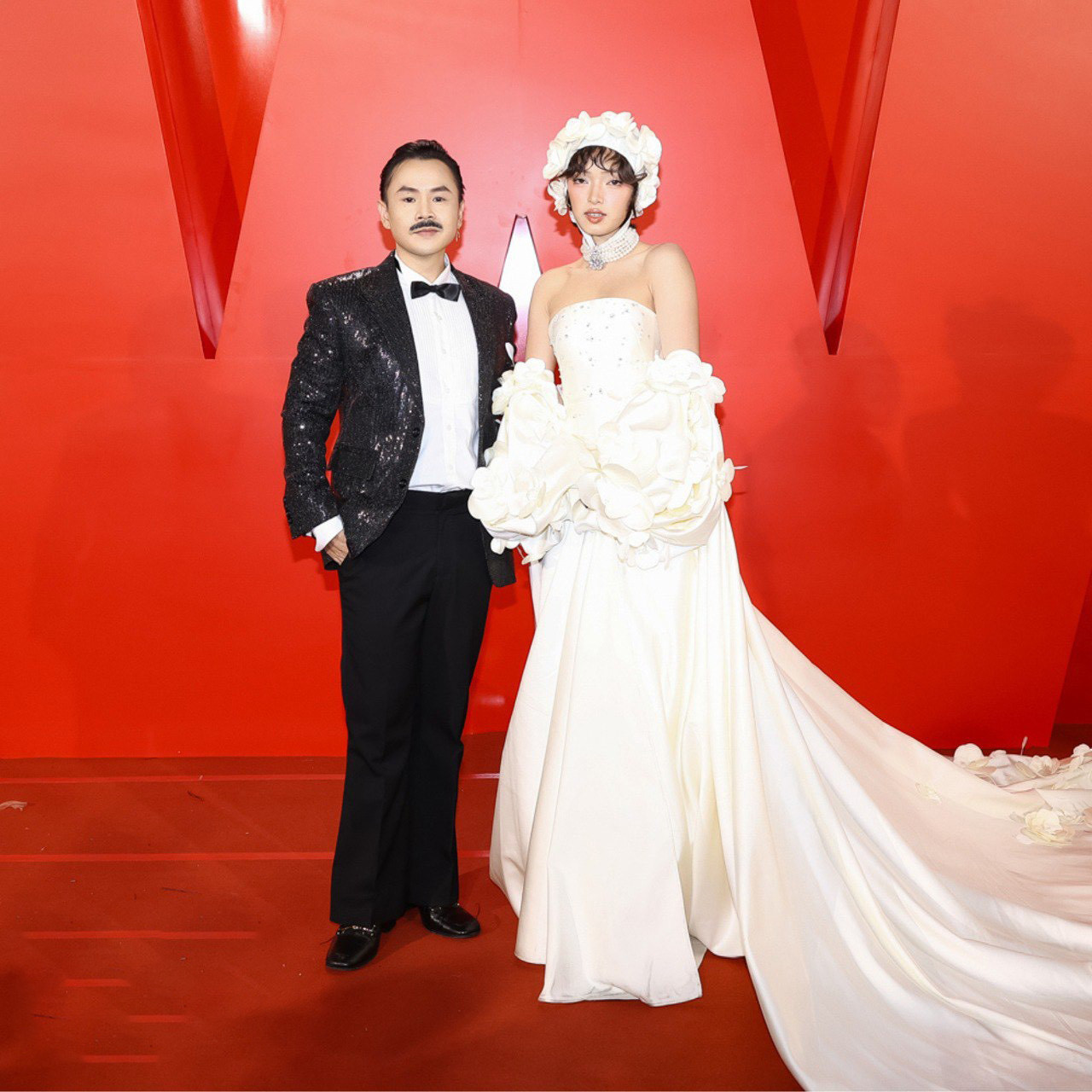 Binz sóng đôi cùng Châu Bùi tại thảm đỏ. Huấn luyện viên Rap Việt khác lạ khi để râu cùng phong cách chững chạc. Trong khi đó, Châu Bùi ghi điểm với thiết kế cúp ngực, phụ kiện đội đầu độc đáo.