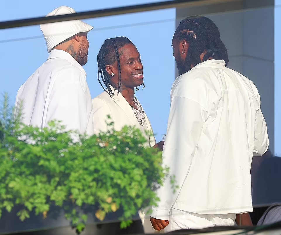 Travis Scott (giữa) mang phụ kiện bản to đến tiệc toàn sao. Nam ca sĩ xuất hiện sau khi được tòa tha bổng trong vụ kiện hình sự sau đêm tiệc có 10 người chết, gần 5.000 bị thương tại lễ hội âm nhạc Astroworld.