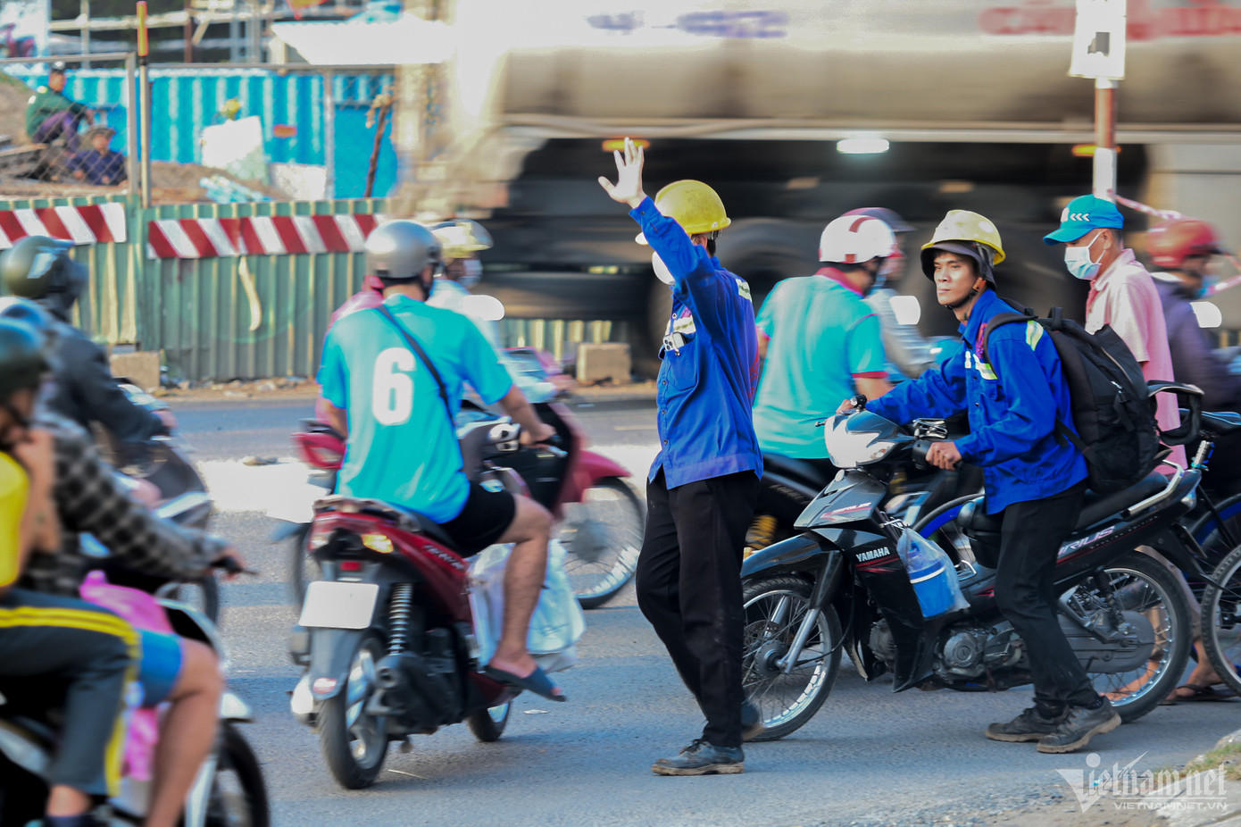 Để không phải đi xa quay đầu xe, hai công nhân đã giơ tay xin đường, dắt xe qua đoạn nút giao bị rào chắn ở đường Nguyễn Hữu Thọ hướng về huyện Nhà Bè.