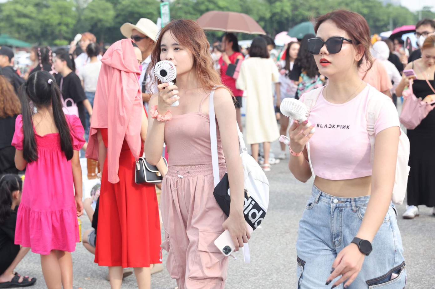 Sau cơn mưa giông lớn buổi trưa, thời tiết Hà Nội oi trở lại. Khán giả chuẩn bị quạt cầm tay để tránh nóng. Do không có ghế ngồi trước cổng sân vận động, người hâm mộ phải tìm cách tránh nóng, trú chân ở những bóng mát trước giờ vào sân khấu.