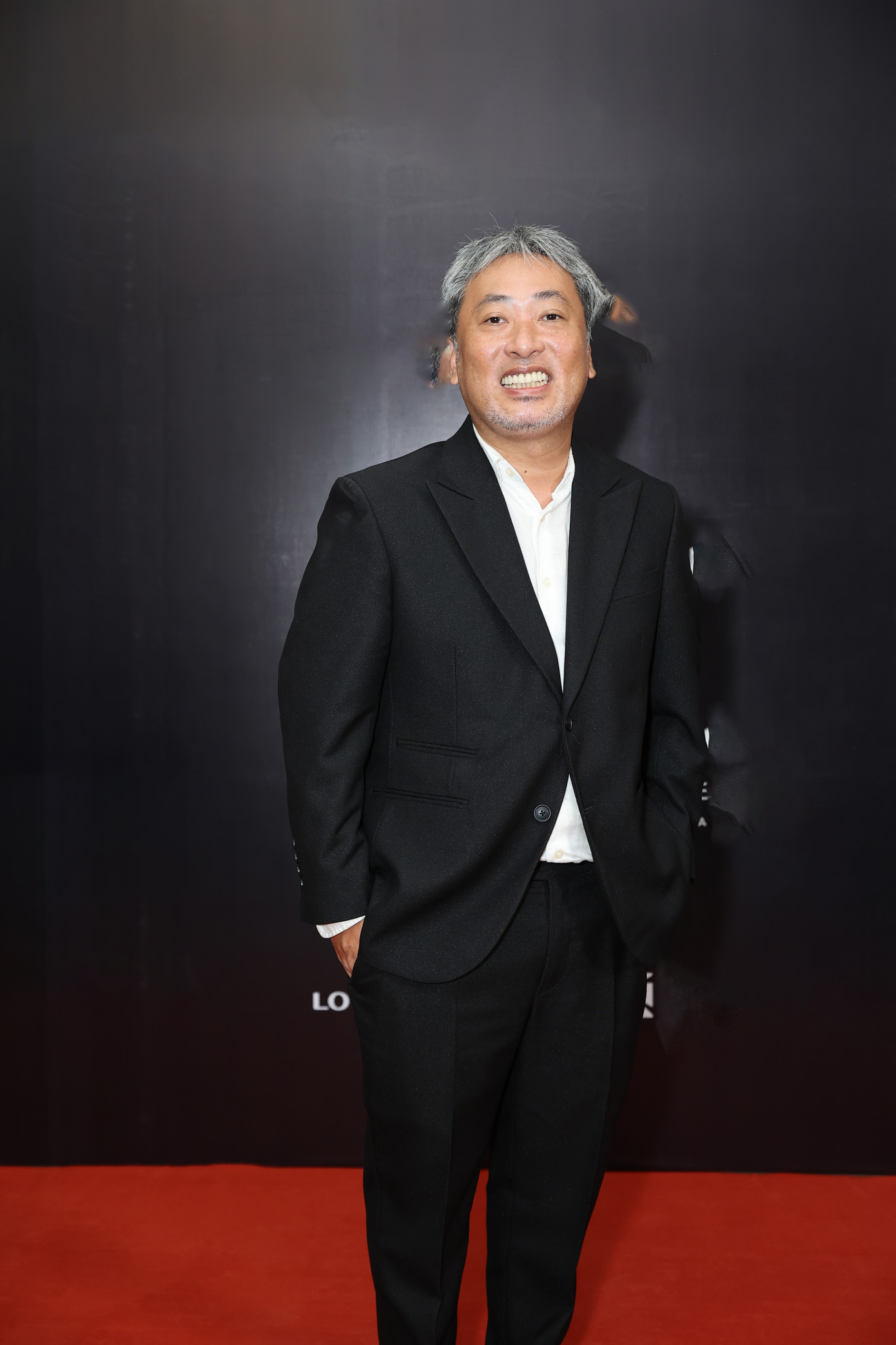 Đạo diễn Nguyễn Quang Dũng diện vest đen trẻ trung dự thảm đỏ. Giám khảo Vietnam Idol sắp tới ra mắt phim remake từ phim truyền hình Đất phương Nam.