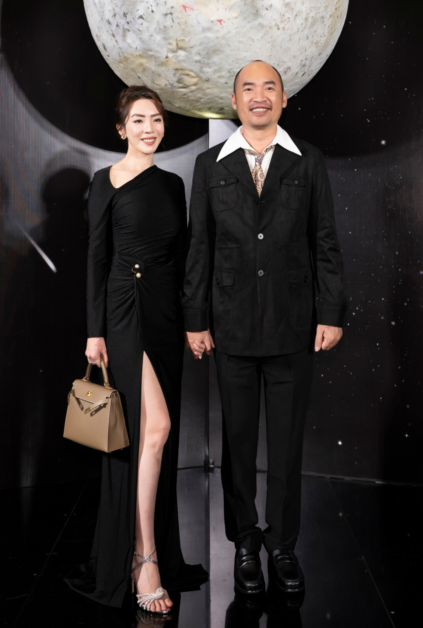 Thu Trang diện váy xẻ tà cao dự show thời trang. Tiến Luật đến show thời trang với trang phục vest đen lịch lãm. Thu Trang diện váy xẻ tà cao dự show thời trang. Tiến Luật đến show thời trang với trang phục vest đen lịch lãm.