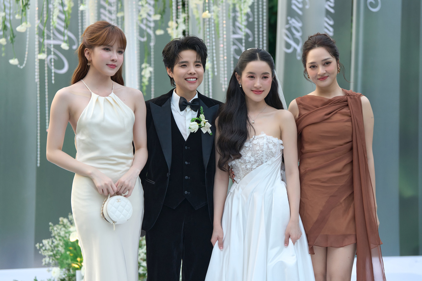 Thiều Bảo Trâm (ngoài cùng bên trái) mặc váy cổ yếm, chất liệu lụa đến ngày vui của Vũ Cát Tường và bạn gái. Ca sĩ Bảo Anh mặc áo nâu, kiểu tóc búi cao.