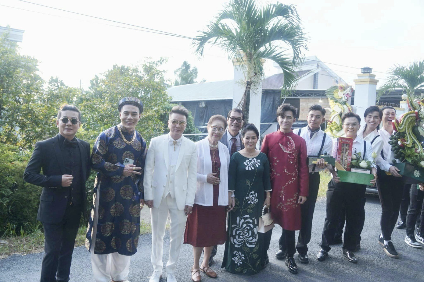 Họ nhà trai chụp ảnh trước khi bước vào nhà cô dâu chuẩn bị làm lễ. Nhiều nghệ sĩ như Đàm Vĩnh Hưng, Vũ Hà, Đại Nghĩa... mặc vest sang trọng dự ngày vui của Puka và Gin Tuấn Kiệt tại Đồng Tháp.