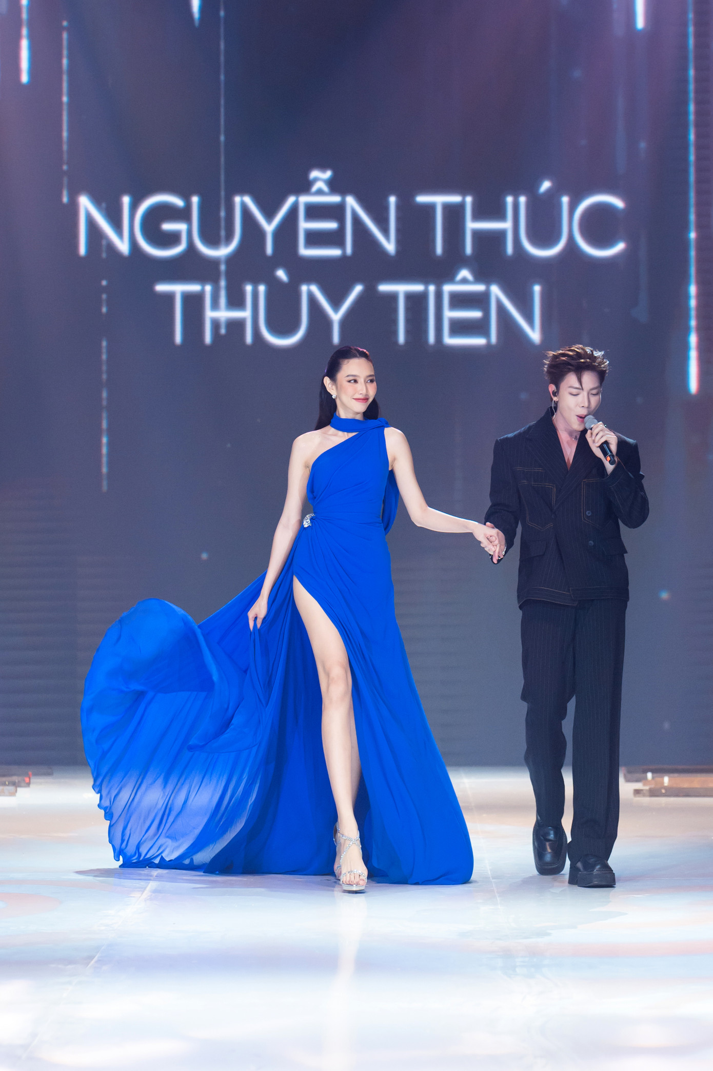 Hoa hậu Thùy Tiên khoe chân dài với thiết kế xẻ tà cao, biểu diễn thu hút. Hiện, khán giả nói sắp ăn cưới Miss Grand International 2021 sau khi cô bắt được hoa cưới từ cô dâu Minh Tú.