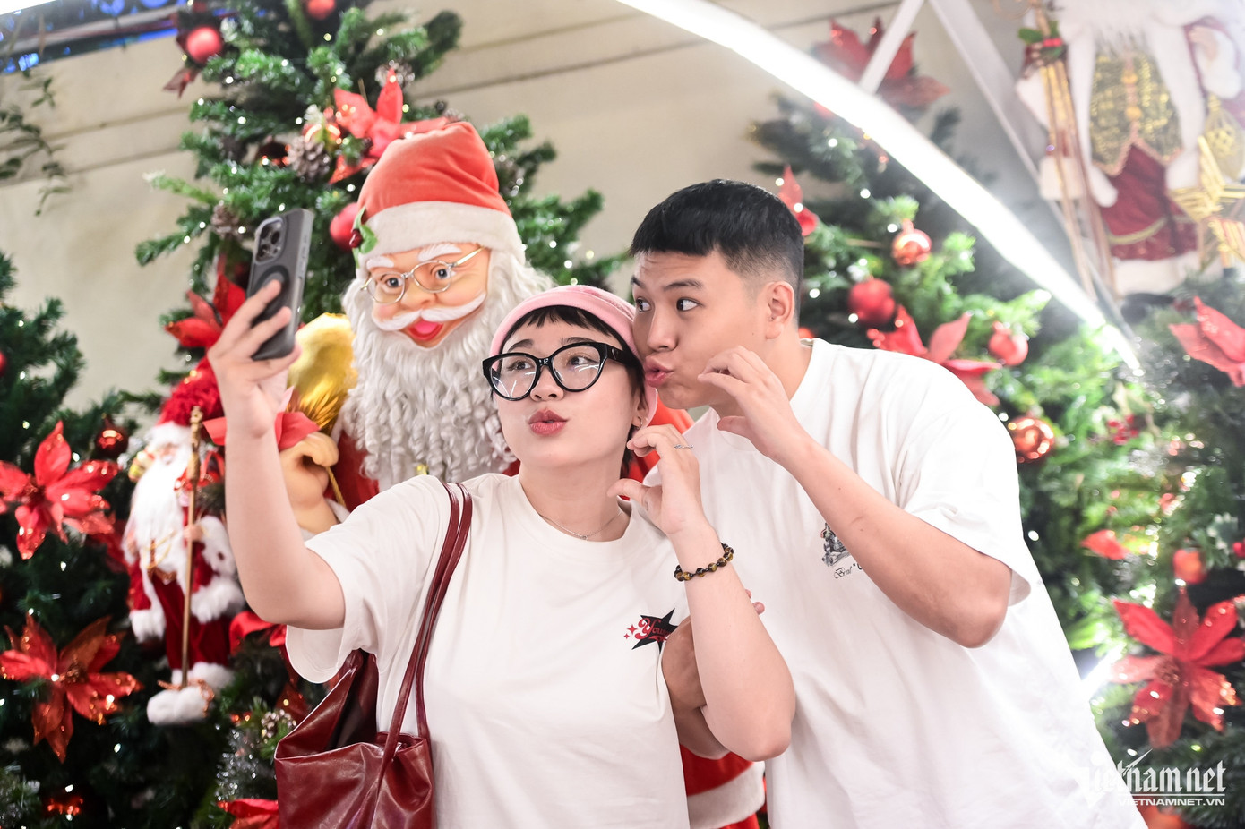 Hân Hân (quận Gò Vấp) cùng bạn tạo dáng chụp hình cùng mô hình ông già Noel. "Giáng sinh là dịp lễ lớn trong năm mà mình rất mong chờ. Mình tới nhà thờ giáo xứ này và rất ấn tượng với hình tượng linh vật Luce rất lớn được thiết kế giống người hành hương mặc áo mưa vàng, mang ủng và gậy gỗ dò đường", Hân nói.