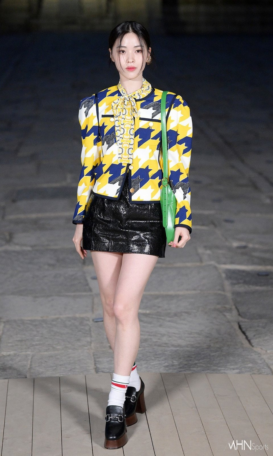 Ryujin (ITZY) lại được khen trẻ trung khi biết cách phối trang phục với áo họa tiết nổi bật, phụ kiện choàng cổ và túi xách nổi bật.