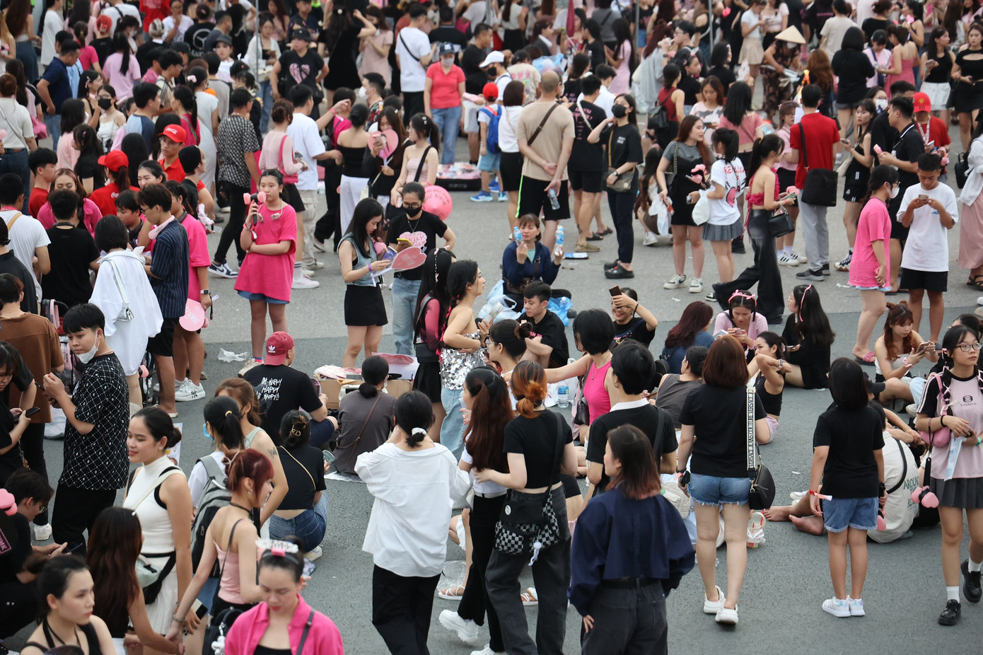 Khán giả ngồi bệt xuống lòng đường ăn uống, nghỉ ngơi trước khi vào sân khấu.