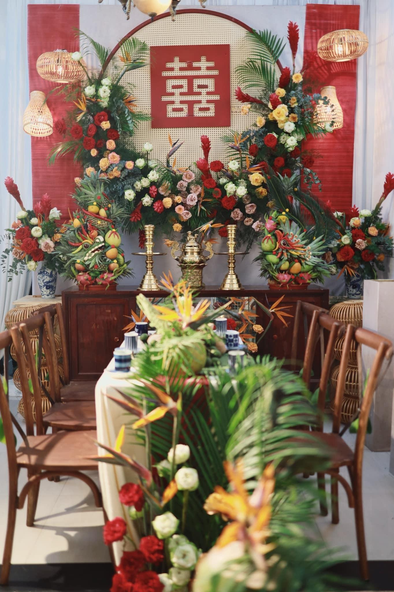 Trước cửa nhà, cổng hoa được trang trí cầu kỳ với nhiều loại hoa khác nhau. Nón lá Việt Nam cũng được cô dâu đưa lên cổng. Ngoài ra, bàn gia tiên gợi không khí miền Tây ngày xưa với cặp chân đèn và lư đồng quen thuộc. Hoa tươi và mây tre được trang trí cầu kỳ, cổ kính. Nữ MC tổ chức Lễ Vu quy dựa trên hình ảnh lễ cưới của cha mẹ từ 30 năm trước. Ảnh: FBNV. Trước cửa nhà, cổng hoa được trang trí cầu kỳ với nhiều loại hoa khác nhau. Nón lá Việt Nam cũng được cô dâu đưa lên cổng. Ngoài ra, bàn gia tiên gợi không khí miền Tây ngày xưa với cặp chân đèn và lư đồng quen thuộc. Hoa tươi và mây tre được trang trí cầu kỳ, cổ kính. Nữ MC tổ chức Lễ Vu quy dựa trên hình ảnh lễ cưới của cha mẹ từ 30 năm trước. Ảnh: FBNV.