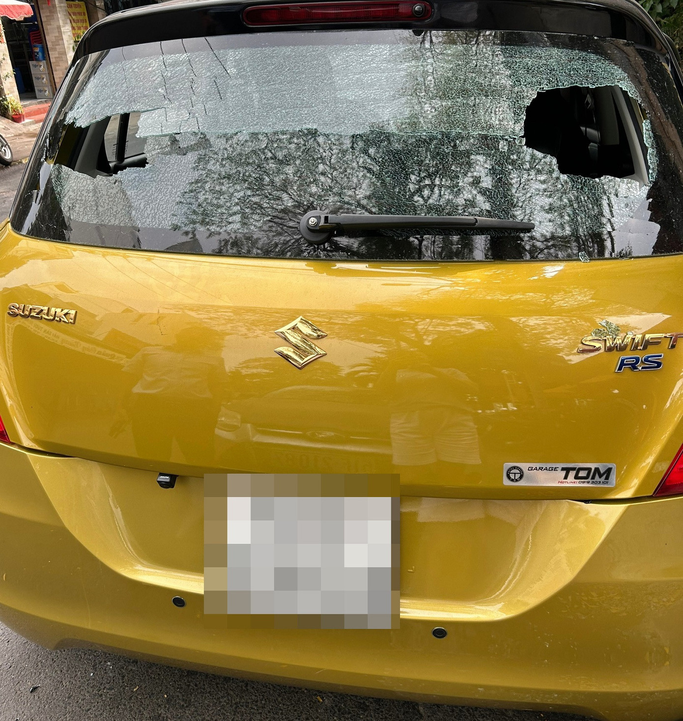 Kính phía sau ô tô bị thủng hai mảng lớn do bị bi sắt xuyên qua. Ảnh: N.T