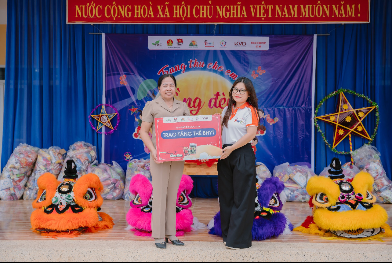 Cô Mai Thị Loan, Hiệu trưởng Trường TH Lê Đình Chinh (Đắk Lắk) thay mặt học sinh nhận tài trợ thẻ bảo hiểm y tế từ Đại diện iSMART.