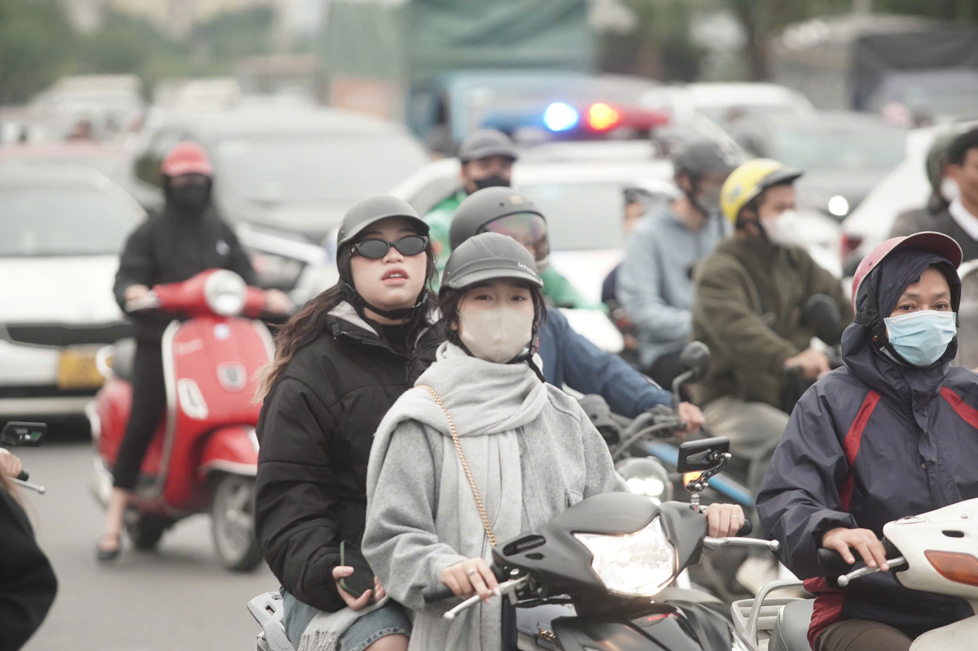 Nhóm bạn trẻ mặc kín, quấn khăn len đi xe máy vào sân vận động chờ đổi vé. Nhiệt độ ngoài trời đang vào khoảng 16-20 độ C. Nhóm bạn trẻ mặc kín, quấn khăn len đi xe máy vào sân vận động chờ đổi vé. Nhiệt độ ngoài trời đang vào khoảng 16-20 độ C.