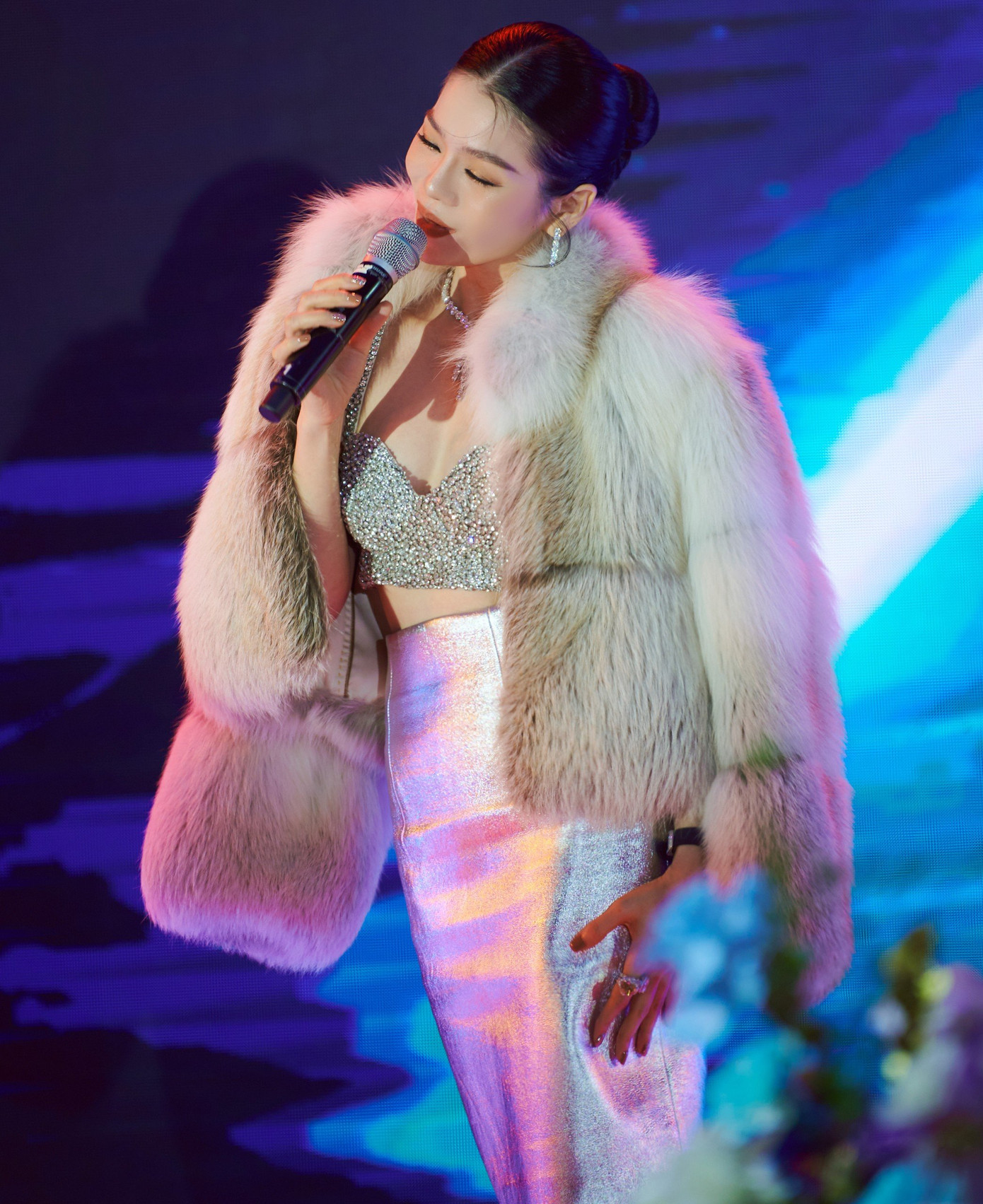 Ca sĩ Lệ Quyên diện áo hai dây đính sequins kèm chân váy ánh bạc. Nữ ca sĩ kết hợp áo khoác lông khi biểu diễn trên sân khấu. Thời tiết Hà Nội dưới 10 độ C nhưng nữ ca sĩ vẫn diện trang phục biểu diễn gợi cảm khi lên sân khấu.