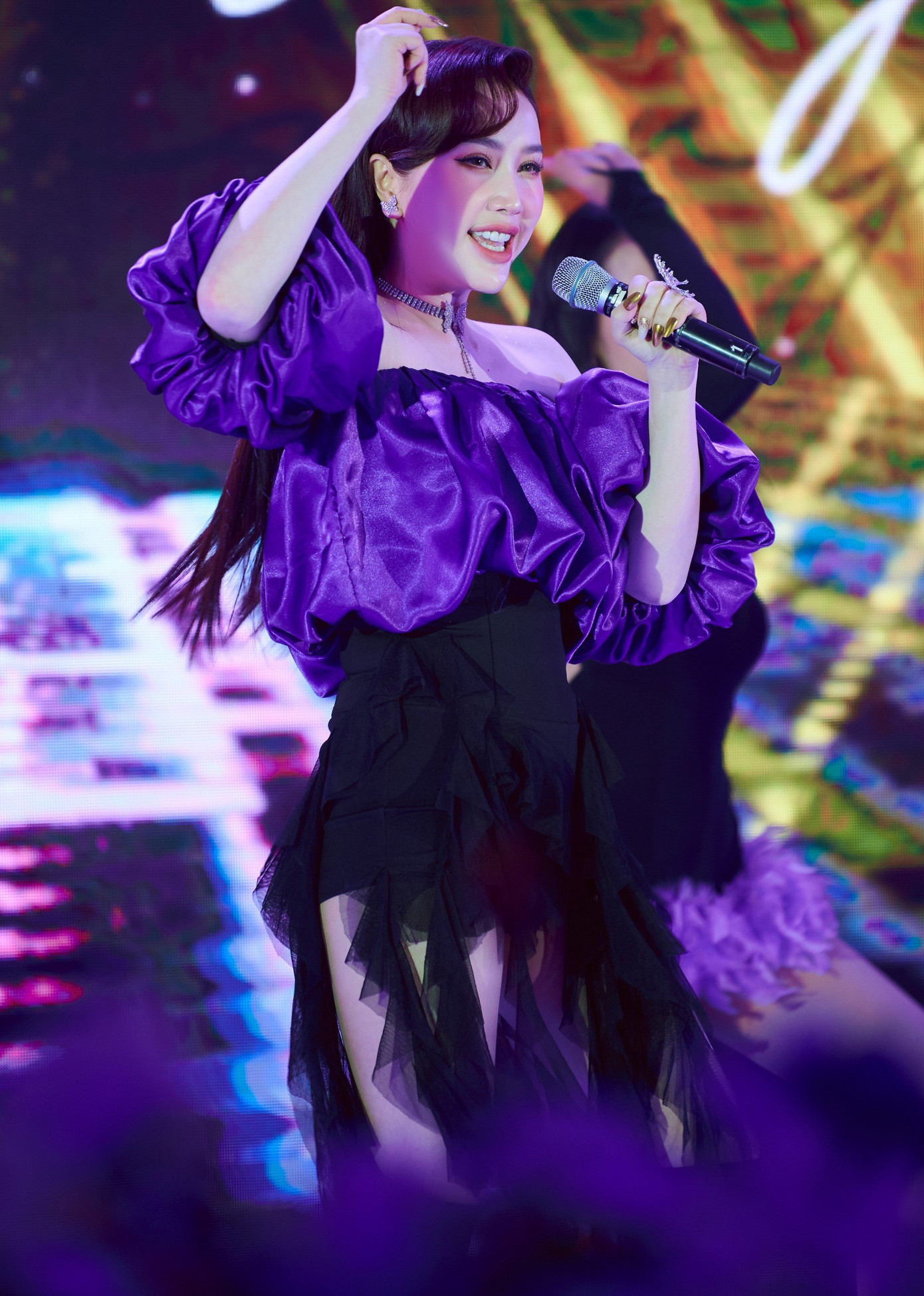 Ca sĩ Bảo Thy xuất hiện tại đêm nhạc với phong cách trẻ trung. Trang phục bèo nhún 3D tạo hiệu ứng trình diễn và giúp cô khoe vai thon trên sân khấu.