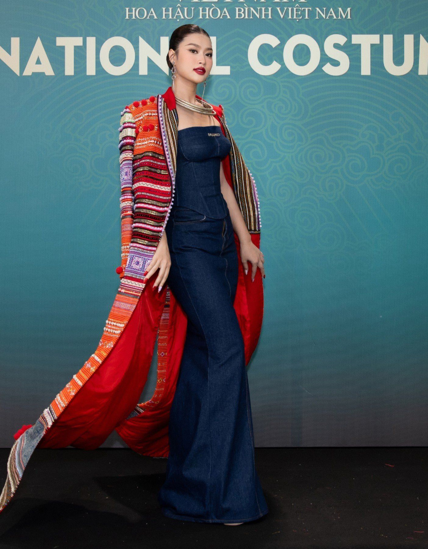 Đương kim Hoa hậu Hòa bình Việt Nam tôn vinh văn hóa thổ cẩm với phần áo choàng dài, thân váy cúp ngực bó sát tôn dáng.