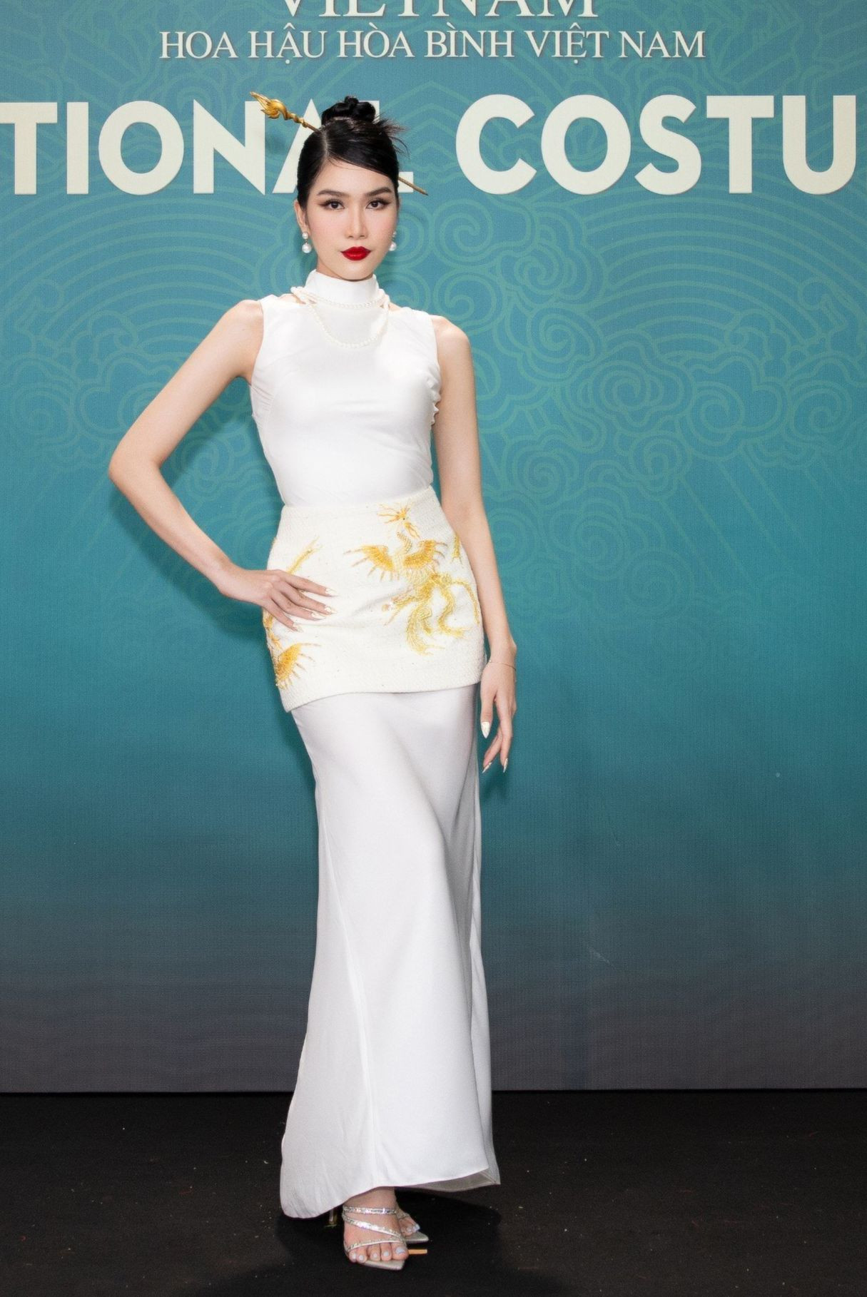 Trang phục đơn sắc với phần chân váy in hình phượng hoàng kim quyền lực của Phương Anh. Á hậu 1 Hoa hậu Việt Nam 2020 chọn màu son đỏ quyền lực.