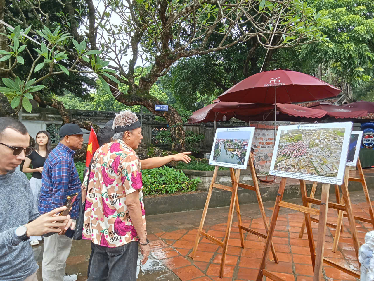 Du khách quốc tế quan tâm tới những hình ảnh tiêu biểu của Hà Nội. Bà Jeanette Freudiger đến từ Thụy Sĩ (trái) ấn tượng với bức ảnh sông Hồng nhìn từ trên cao của tác giả Phạm Hùng. "Bây giờ tôi hiểu vì sao dòng sông nổi tiếng chảy trong lòng thành phố của các bạn có tên gọi như vậy, màu đỏ phù sa của dòng sông rất đặc trưng. Nó nổi bật trên nền xanh ngắt của rất nhiều cây cối. Dọc theo bờ sông là Hà Nội, với những ngôi nhà nhỏ mọc lên san sát, rất đặc trưng và thú vị”, bà nói.