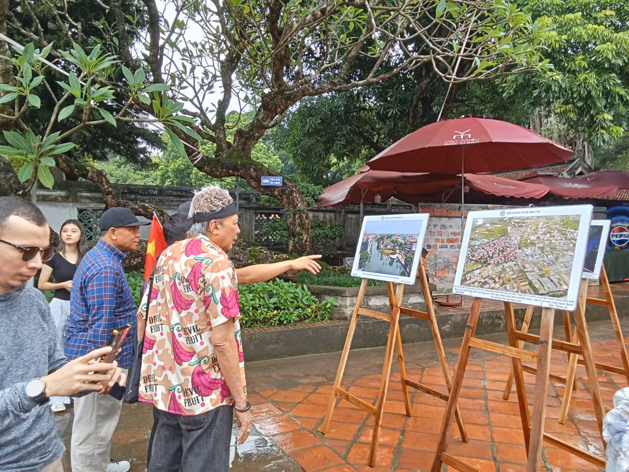 Du khách quốc tế quan tâm tới những hình ảnh tiêu biểu của Hà Nội. Bà Jeanette Freudiger đến từ Thụy Sĩ (trái) ấn tượng với bức ảnh sông Hồng nhìn từ trên cao của tác giả Phạm Hùng. "Bây giờ tôi hiểu vì sao dòng sông nổi tiếng chảy trong lòng thành phố của các bạn có tên gọi như vậy, màu đỏ phù sa của dòng sông rất đặc trưng. Nó nổi bật trên nền xanh ngắt của rất nhiều cây cối. Dọc theo bờ sông là Hà Nội, với những ngôi nhà nhỏ mọc lên san sát, rất đặc trưng và thú vị”, bà nói.