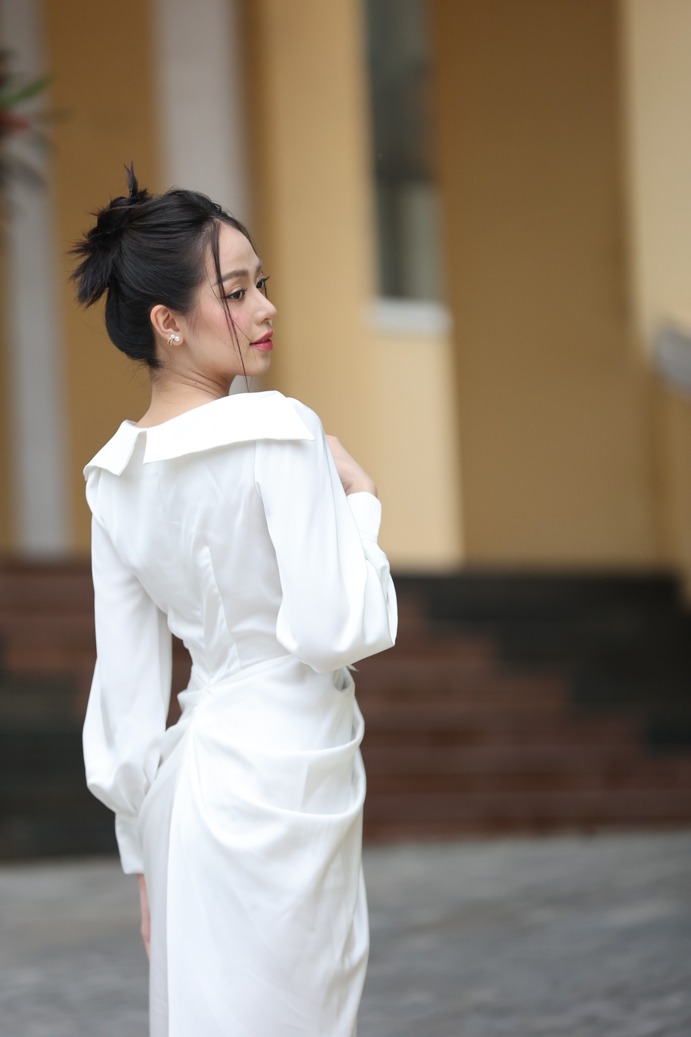 Hoa hậu Thanh Thuỷ diện váy trắng trễ vai kiểu cổ tim duyên dáng. Người đẹp búi tóc sang trọng và trang điểm nhẹ nhàng.