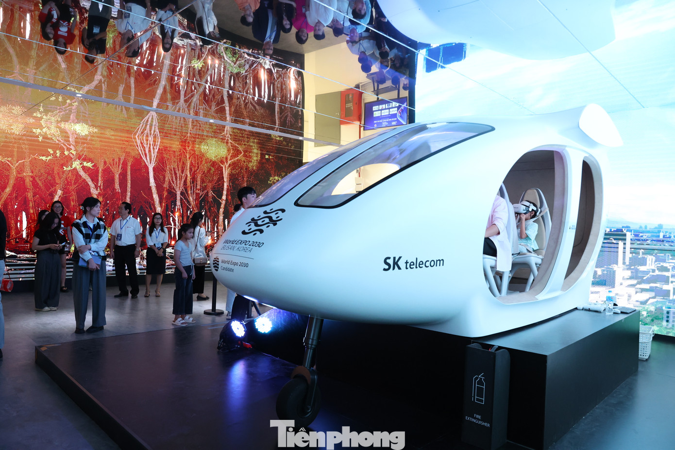 Người tham dự thích thú với trải nghiệm thực tế ảo (VR) trên máy bay nhỏ UAM. SK kỳ vọng, đây sẽ là phương tiện hữu hiệu vận chuyển để con người và hàng hoá, ở những khu dân cư mật độ đông đúc. Qua kính VR, khách hàng tận thấy quá trình bay. Đây cũng là sản phẩm chủ lực, phương tiện giao thông quan trọng được SK giới thiệu tại Hội chợ triển lãm thế giới 2030 - World Expo 2030 tại Busan (Hàn Quốc). Cũng tại sự kiện, SK còn giới quá trình chuyển hoá khí hydro sang điện năng, được thực hiện chỉ trong một chiếc máy.