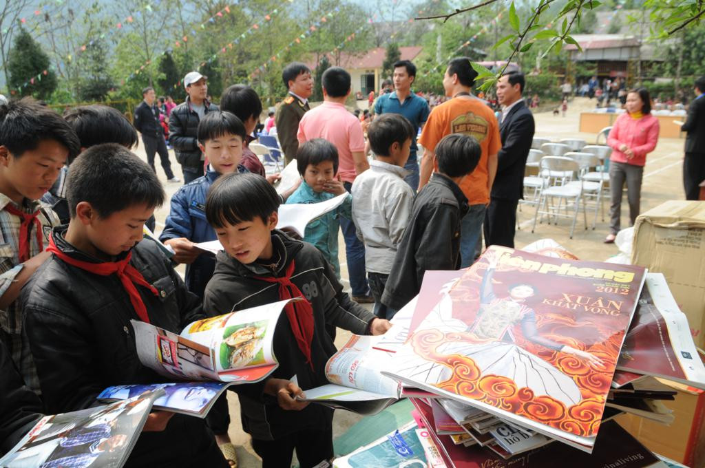 Các em nhỏ say mê đọc báo