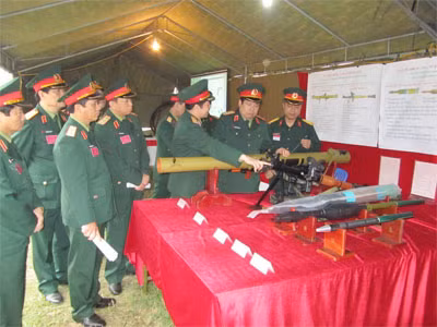 Bộ trưởng Bộ Quốc phòng Phùng Quang Thanh nghe giới thiệu về súng chống tăng vác vai RPG-29 và các loại đạn chống tăng và bộ binh kiểu mới do Việt Nam tự chủ sản xuất. Từ ngoài vào trong là: 1. Đầu đạn mảnh OG-7V để diệt người 2. Đầu đạn 2 đầu nổ PG-7VR để diệt các loại tank có giáp phản ứng nổ. 3. Đầu đạn PG-29V dùng cho RPG 29. 4. Súng chống tăng RPG-7V1 đủ option 5. Súng chống tăng vác vai RPG-29