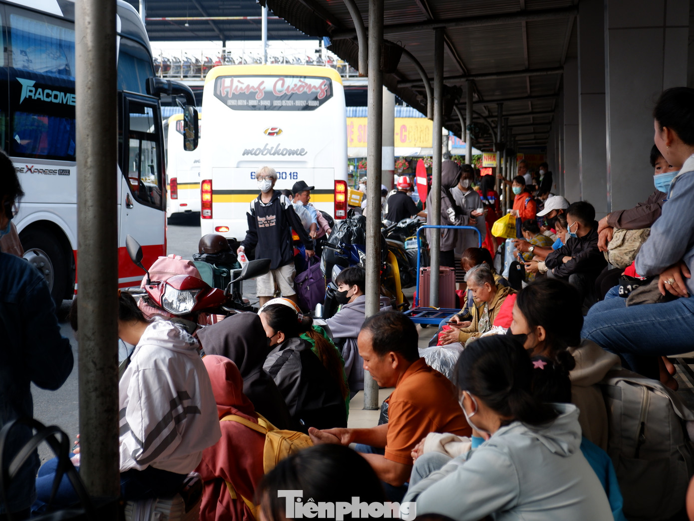 Lượng hành khách tăng cao, nhiều người ngồi tạm trước các bậc thềm chờ đến giờ lên xe.