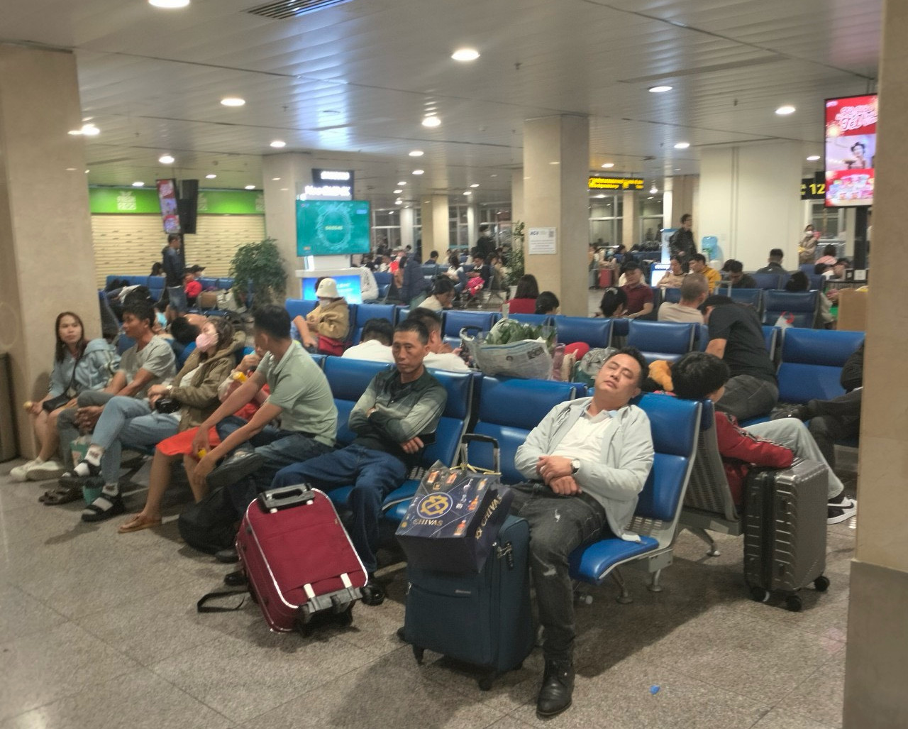 Một số hành khách tranh thủ nghỉ ngơi trước giờ lên tàu bay.