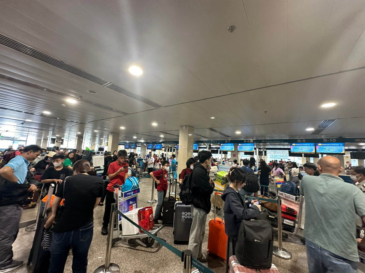 Hàng nghìn hành khách lỉnh kỉnh đồ đạc chuẩn bị làm thủ tục lên máy bay về quê đón Tết bên gia đình.