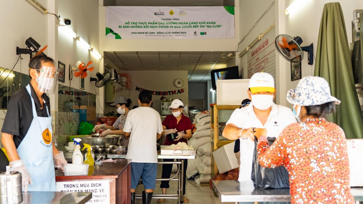 Người dân khó khăn tiếp nhận các suất ăn được cộng đồng chia sẻ.