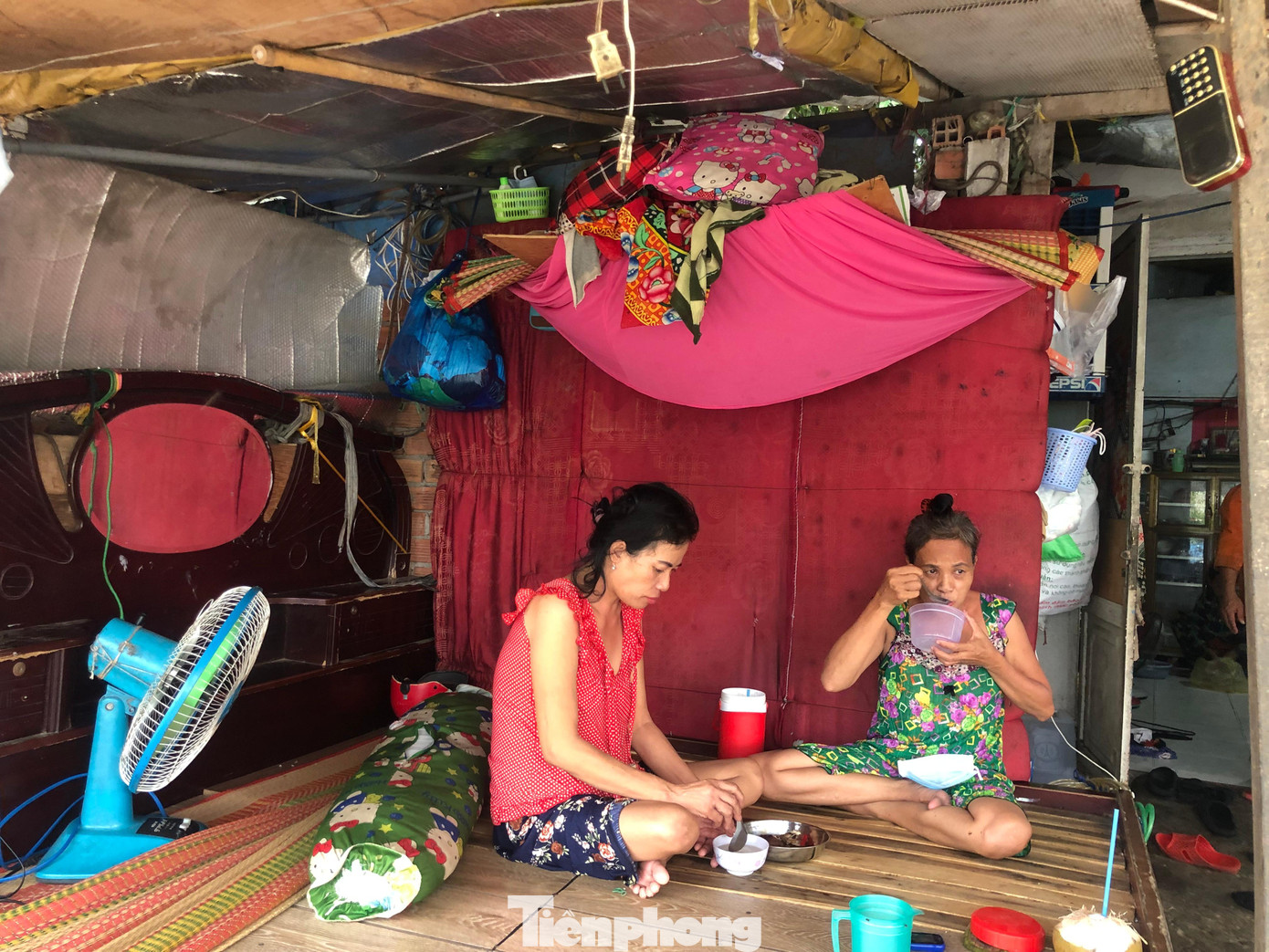 Bà Nhàn (bìa trái) bị tai biến liệt người hơn 4 tháng nay. Từ người phụ nữ trụ cột, lo cho hơn chục con người trong gia đình, giờ bà Nhàn bất lực ngồi một chỗ, nhìn cả gia đình thất nghiệp, lo đói từng ngày...