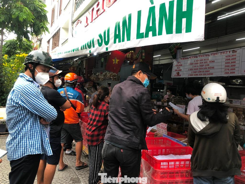 Nhân viên liên tục yêu cầu giãn cách, nhưng lượng khách quá đông, đứng lớp trong lớp ngoài và dường như không còn khoảng trống tại cửa tiệm.