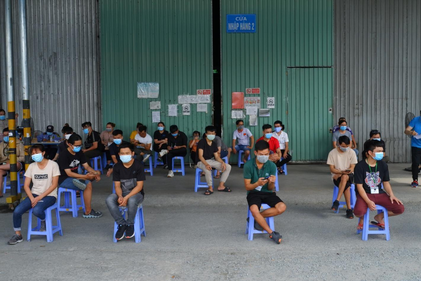 Người dân ngồi giãn cách trong khi chờ đến lượt Người dân ngồi giãn cách trong khi chờ đến lượt