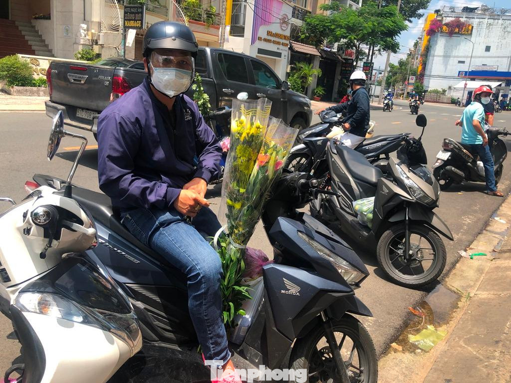 Người dân tranh thủ mua đồ cúng trong rằm tháng Bảy. "Dù các điểm bán trái cây, hoa cúng đều đông người, mình lo lắng khi ra ngoài nhưng cũng tranh thủ mua nhanh vì không thể đặt các mặt hàng này online" - anh Tú nói.