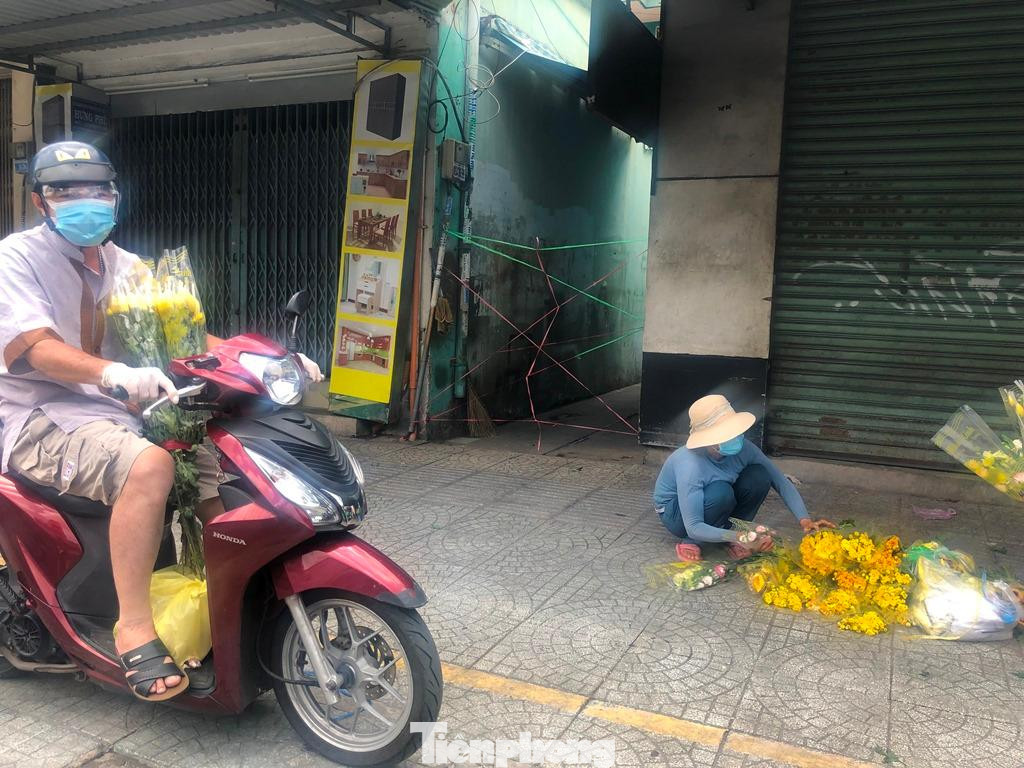 Một số người tranh thủ đem hoa xuống vỉa hè bán dịp rằm, kiếm được đồng nào đỡ đồng nấy trong những ngày dịch.