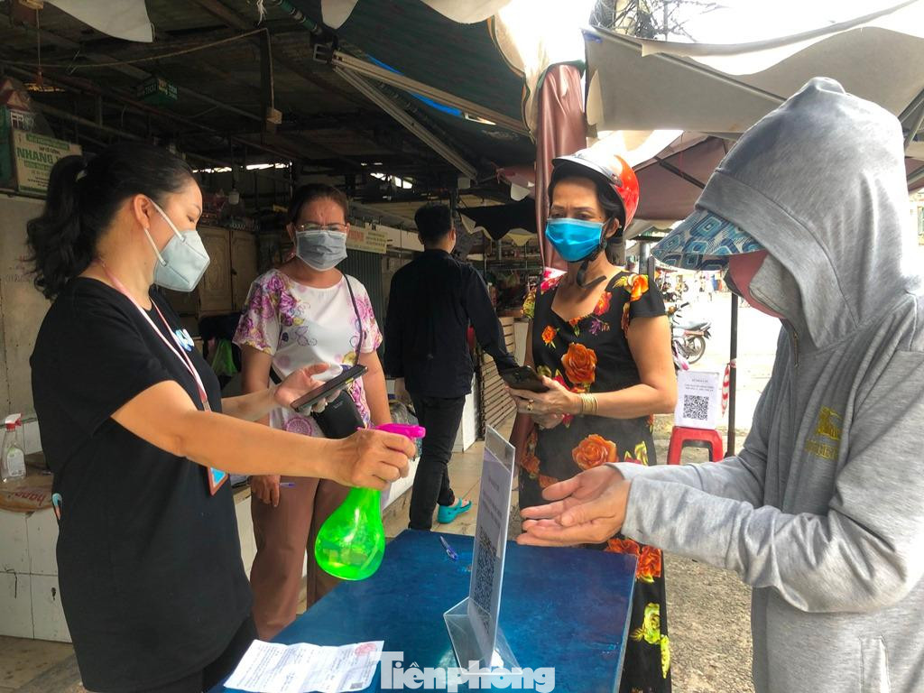 Ban quản lý chợ khử khuẩn khách hàng trước khi vào mua sắm