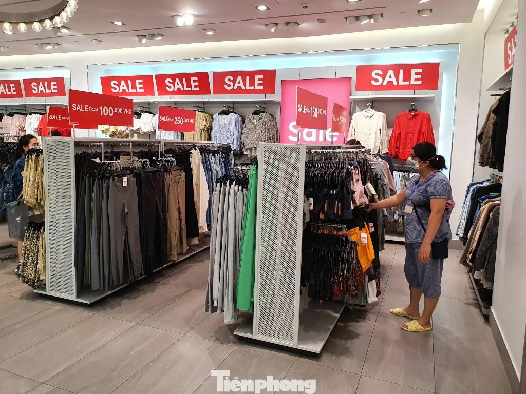 Một shop thời trang trưng biển sale đỏ rực chỉ từ 100.000 đồng/sản phẩm nhưng khách đến mua sắm chỉ lác đác.