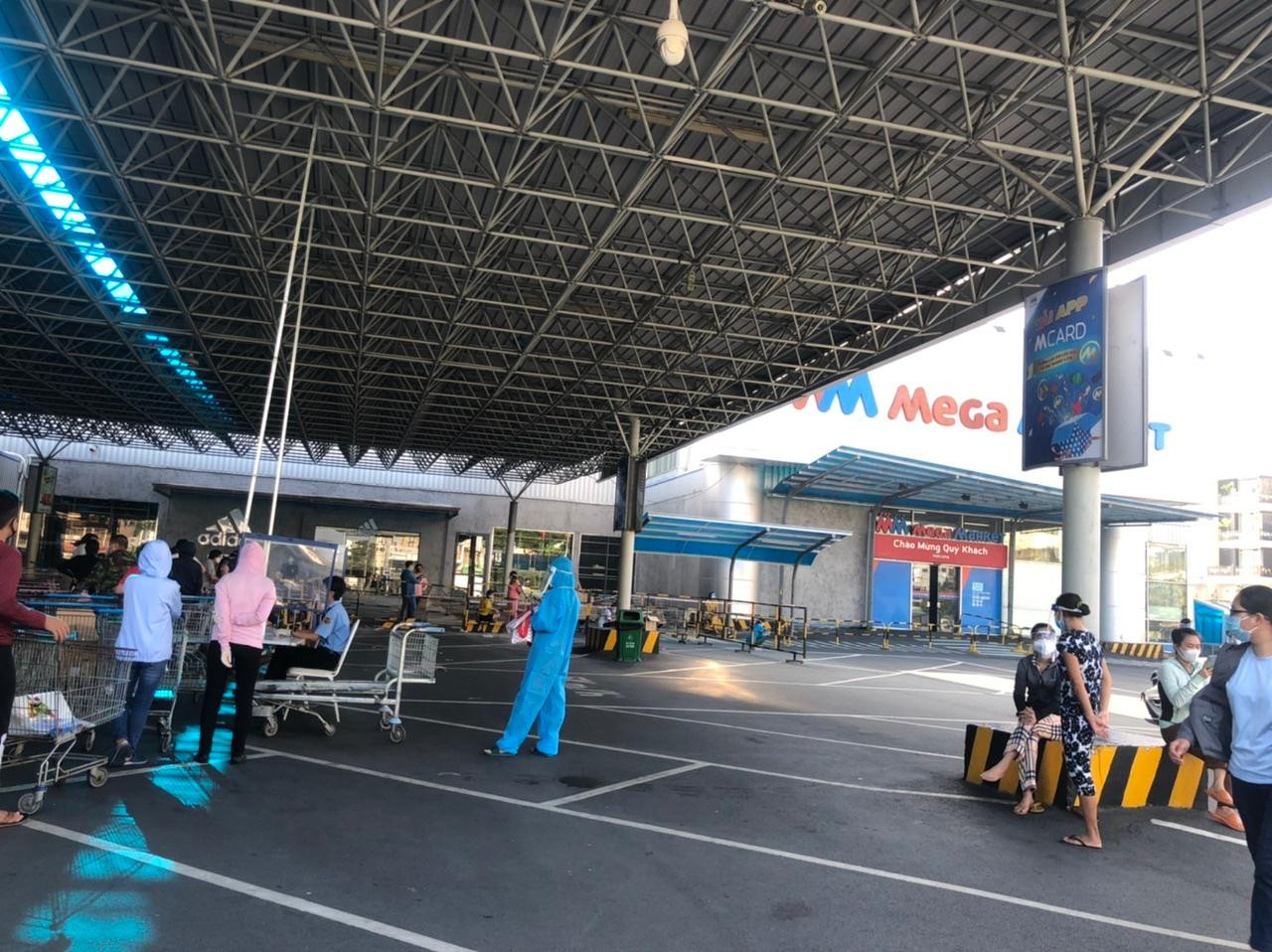 Nhân viên siêu thị điều tiết lươngj khách trước giờ siêu thị mở cửa.