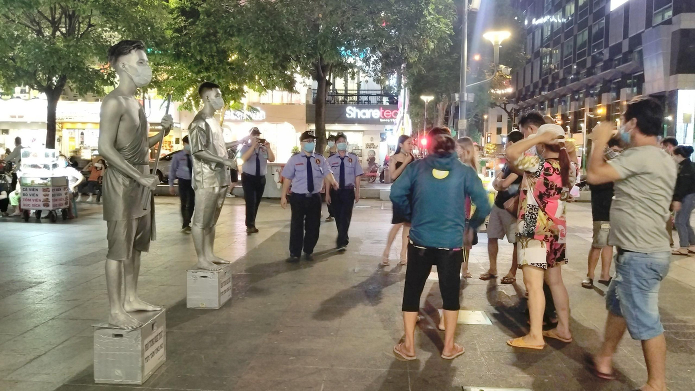 Phố đi bộ Nguyễn Huệ (Q.1) không còn cảnh tấp nập về chiều tối, lực lượng bảo vệ thường xuyên nhắc nhở du khách đeo khẩu trang khi đi dạo.