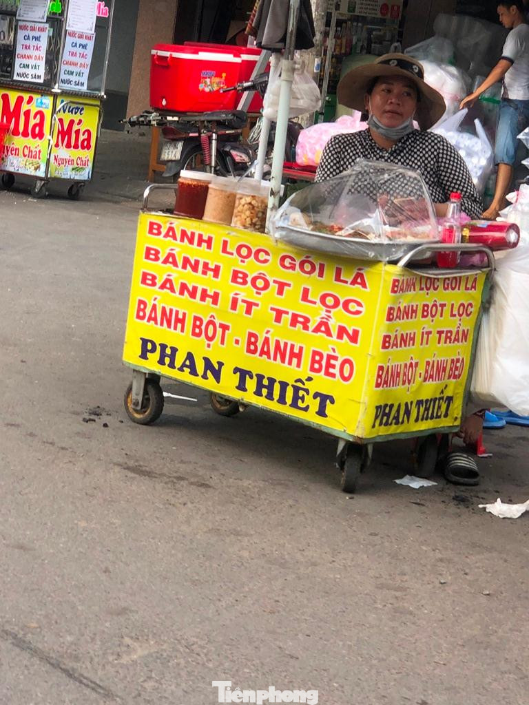 Người bán hàng mang khẩu trang chỉ để... cho có. Một số người kinh doanh cho hay, trời nắng nóng nên tranh thủ lúc không có khách, kéo khẩu trang xuống chút cho dễ thở (?!).