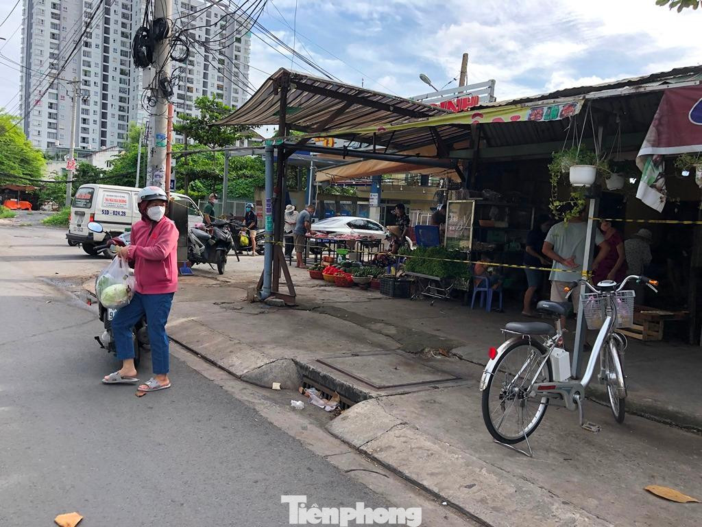 Một điểm bán rau tự phát chăng dây để giữ khoảng cách, nhưng người mua đều "chui dây" vào bên trong lựa hàng thoải mái.