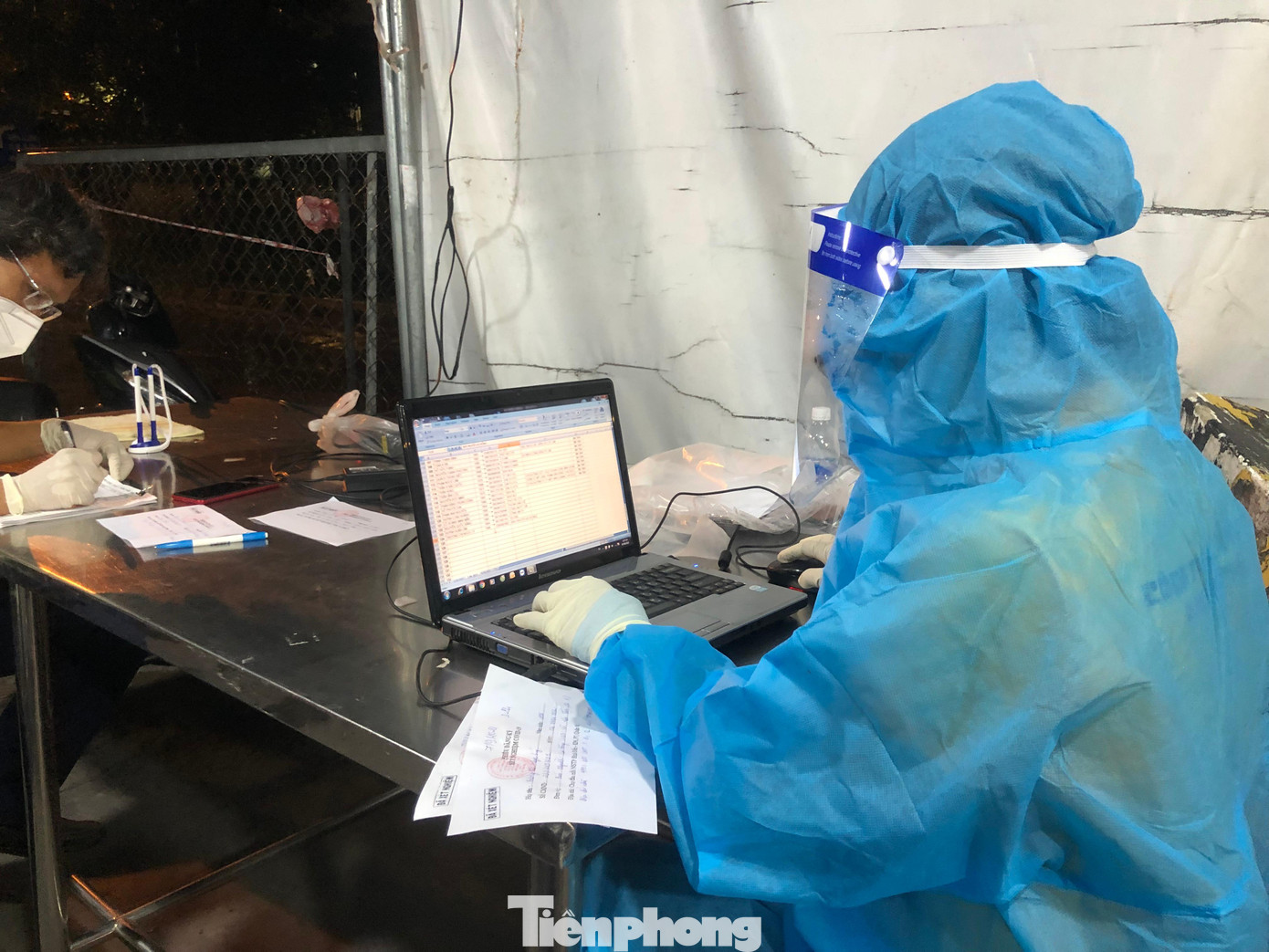 Nhân viên y tế cập nhật thông tin ngay trước cổng ra vào