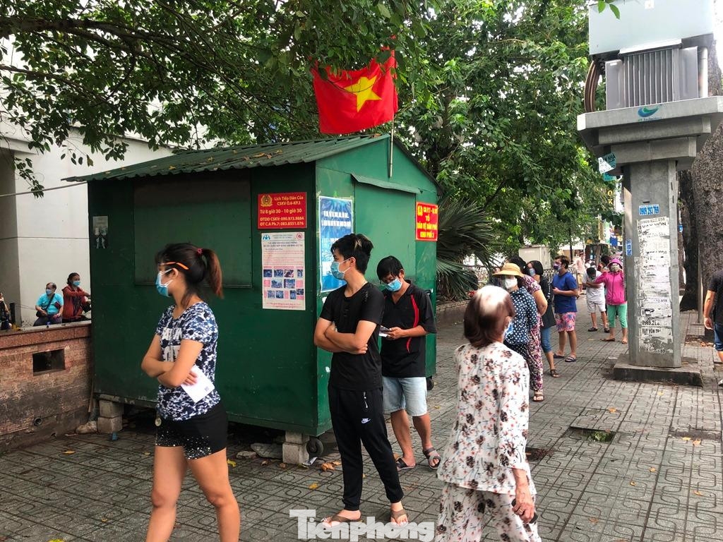 Mọi người đều cầm sẵn giấy mua hàng trên tay. Đây là phiếu mua hàng tại siêu thị phân theo ngày chẵn lẻ do phường cấp cho người dân, nhằm hạn chế tập trung quá đông người.