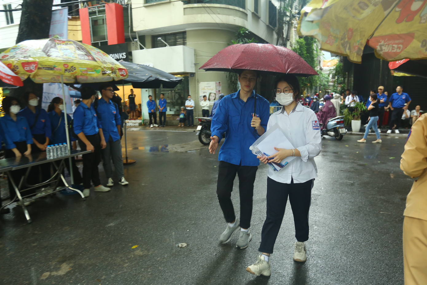 Hình ảnh các tình nguyện viên không ngại mưa gió hỗ trợ thí sinh.