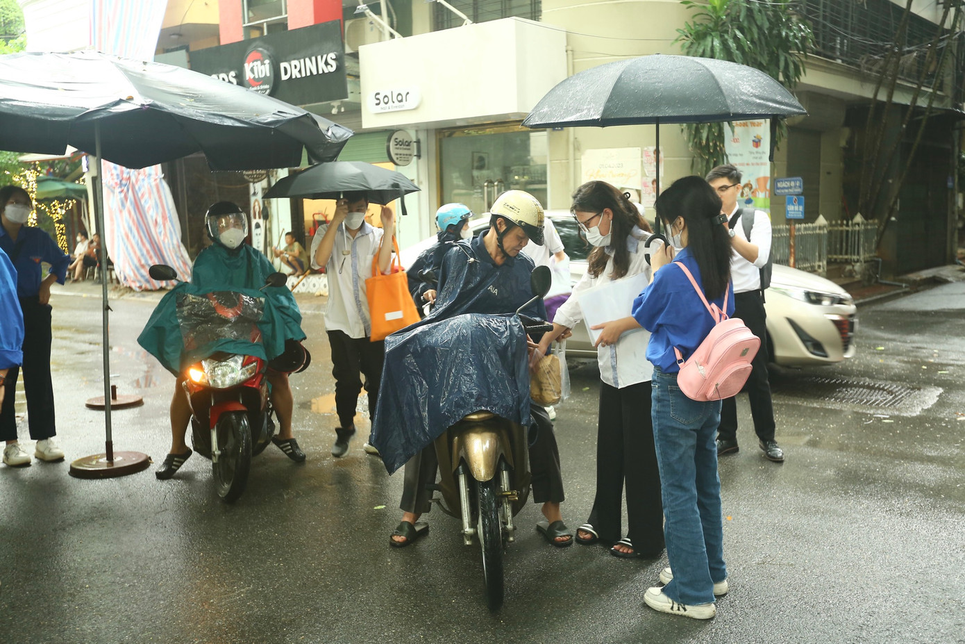 Học sinh và phụ huynh đều phải trang bị áo mưa, ô... để đến địa điểm thi, tuy nhiên chỉ có thể đến cổng.